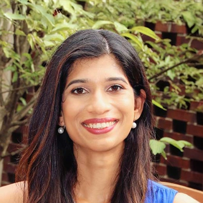 Pediatric Dentist Carla de Sa Smiling In Blue Dress Outdoors